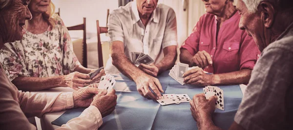 Group of seniors playing cards in the retirement house