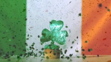 Küçük yeşil kağıt yoncaları düşme ve cupcake yeşil sırlı ve İrlanda bayrağı arka plan ve ön plan üzerinde St Patrick's Day için uçan dijital parçacıklar karşı Yeşil yonca dekorasyon ile animasyon 