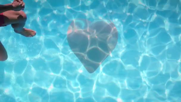 在前景上红心的游泳池上跳的高加索夫妇的数字组合 — 图库视频影像