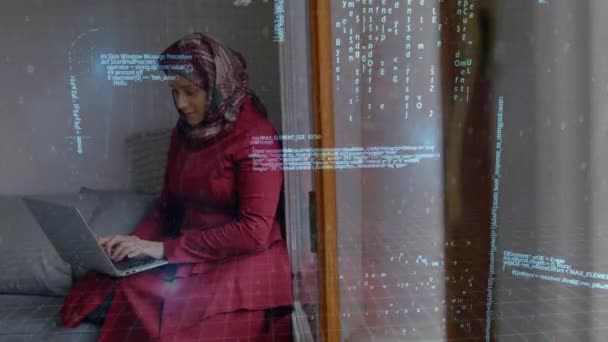 穆斯林妇女戴头巾的侧视图的数字组合在她的房间里快速录制笔记本电脑与二进制代码背景 — 图库视频影像