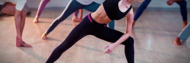 Fitness stüdyosunda germe egzersizi yapan insanların portresi