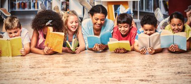 Mutlu öğretmen öğrencilerle kitaplığında yatarken kitap okuma