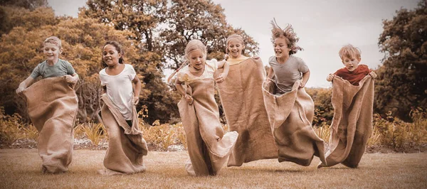 Niños Haciendo Una Carrera Sacos Parque Día Soleado — Foto de Stock