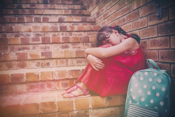 階段でレンガの壁に取り付けられている悲しいのブルネットの少女 — ストック写真