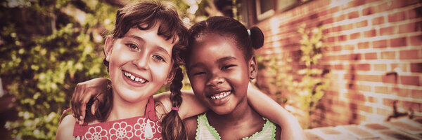 Two friendly girls posing and smiling at the camera