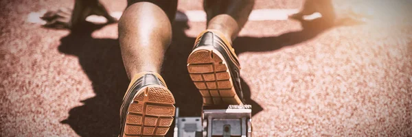 Feet of an athlete on a starting block about to run, Close-up