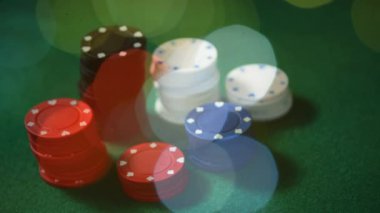 Poker fişleri ve bokeh etkileri ile yeşil bir tabloda atılan kartlar dijital bileşik