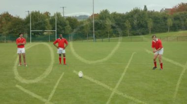 Strateji kağıt ön plan üzerinde hareket ederken futbol sahasında futbol oynarken çok etnik rugby oyuncuları Grubu'nun dijital bileşik