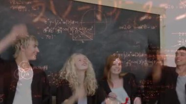 Genç beyaz dijital bileşik animasyon matematiksel semboller ile çevrili bir tahta karşı ayakta mezunları.