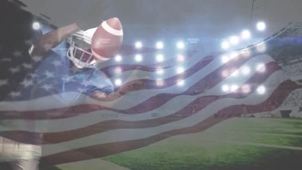 非洲裔美国橄榄球运动员试图赶上足球和美国国旗在全场体育场上挥舞的数字组合 橄榄球运动员在背景下潜水到球场灯光下的足球 — 图库视频影像