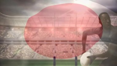 Afro-Amerikan rugby oyuncusu futbol atmadan aşağı beyaz oyuncu ve Japon bayrağı ön planda tam bir stadyum üzerinde sallayarak çalışmalarla sırasında dijital bileşik