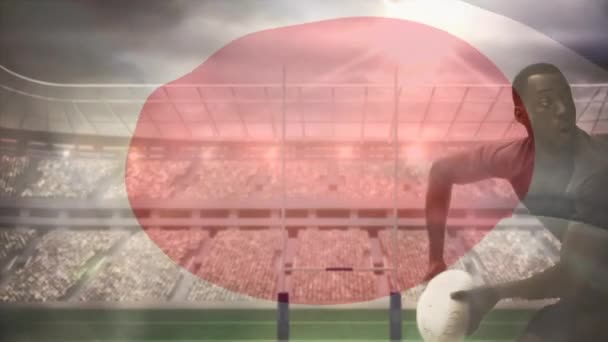 非洲裔美国橄榄球运动员的数字组合将足球扔掉 同时被高加索球员和在全场挥舞的日本国旗在一个完整的体育场里挥舞 — 图库视频影像