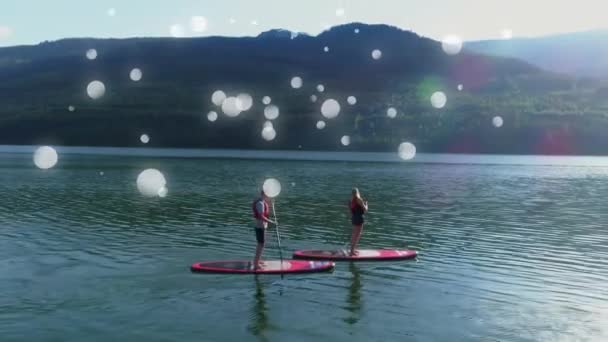 Compuesto Digital Pareja Haciendo Paddle Board Lago Rodeado Burbujas Blancas — Vídeo de stock