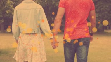 Arkadan görünüş el teslim ve birlikte arka planda ağaçlarıyla bir parkta yürüyüş Kafkas Çift