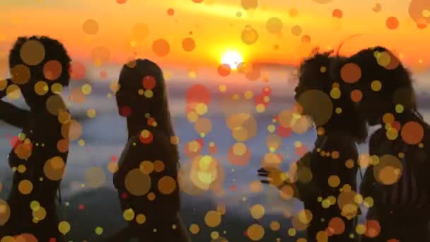 黄色いボケと夕暮れ時にビーチで踊る女性のデジタル複合体効果 — ストック動画