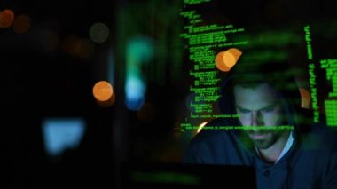Bilgisayarda yazarken kapüşonlu bir karanlık odada bir hacker yakın. Ön plan ve arka plan arayüz kodları ile doldurulur