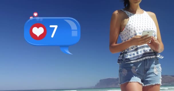 晴れた日にビーチでテキストメッセージを送る白人女性のクローズアップ 前景で彼女の横にカウントと4K上に飛ぶアイコンのハートアイコンとメッセージバブルのデジタルアニメーションです — ストック動画