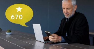 Beyaz yaşlı bir adamın dizüstü bilgisayarının önünde telefonunda gezinirken yakın bir yerde. Onun yanında sayısı 4k artan bir yıldız simgesi ile bir mesaj balonu dijital animasyon