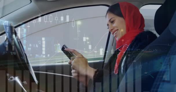 侧视图一个微笑的女人戴着围巾在她的头上发短信在车内 图形和统计的数字动画在前景 中运行 — 图库视频影像
