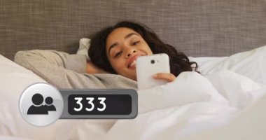 Telefonunu kontrol ederken yatakta gülümseyen İspanyol bir kadının yakın. Ön planda onun yanında bir arkadaş isteği simgesi sayısı 4k artan bir dijital animasyon