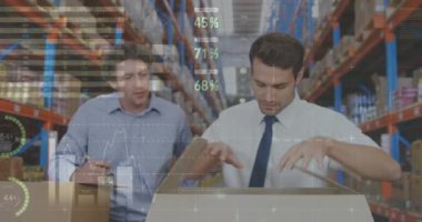 İki Beyaz erkek depo müdürünün yakın ıstabiri. Biri bir paket açarken diğeri arkadan spekülasyon yaparken. Dijital animasyon grafikleri ve istatistikleri ön planda 4k int çalışıyor