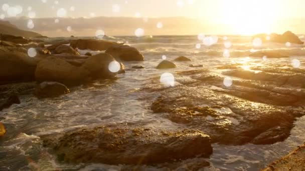 岩の海の夕日を背景に白いボケのデジタル生成アニメーション — ストック動画