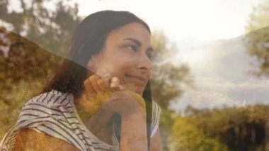 Çenesini tutan ve parkta gülümseyen İspanyol kadının yan görünümü