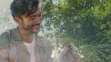 Beyaz bir erkek çiftçinin dijital bileşimi tarlasını ve orman yolunu kontrol ediyor. Çiftçilerin arkasında ağaçlar var.