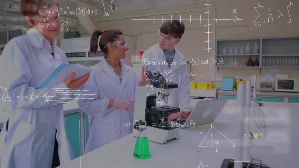 実験室と方程式で満たされた前景で研究している3人の科学者のデジタルコンポジット ある科学者はラップトップで もう1人は顕微鏡を使い もう1人はノートに書き込んでいます — ストック動画