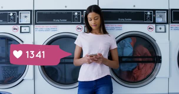 세탁소에서 세탁이 끝나기를 기다리는 전화에 입력하는 여성의 클로즈업 아이콘과 숫자가 — 비디오