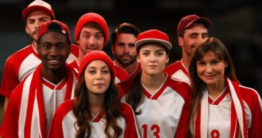 Beyaz ve kırmızı forma giyen sporseverler, grup olarak tezahürat yapıyor. 4k
