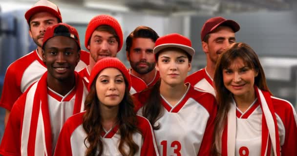 赤と白のジャージを着たスポーツファンのグループの正面図 を応援 — ストック動画