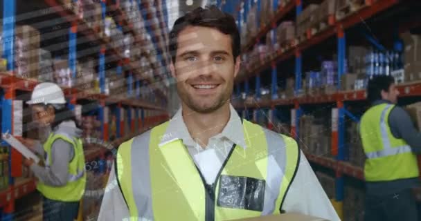 一个白人男性工人微笑的特写 在他身后是另外两个正在检查包裹的工人 图形和统计的数字动画在前景 中运行 — 图库视频影像