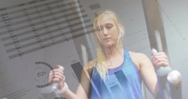 Spor salonunda bacak kaldırma yapan beyaz bir kadının yakın ıstekli. Grafik ve istatistiklerin dijital animasyonön planda 4k çalışan görülür