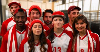 Front view of a group of sports fans wearing red and white jerseys lively cheering 4k