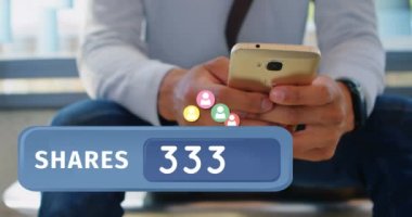 Telefonunu kontrol ederken ofiste oturan bir adamın yakını. Ön planda telefonunu körükle takipçisi simgeleri 4k yukarı uçan bir hisse sayısı kabarcık