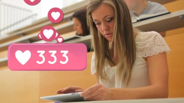 講義ホール内のタブレットを使用した白人女子学生のデジタルコンポジット ハートアイコン付きのピンクのバー 画面上の表示数の増加 — ストック動画