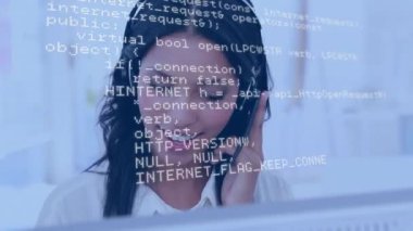 Ön planda hareket eden program kodları ile bir bilgisayar kullanırken kulaklık takan Bir Afrikalı-Amerikalı kadın dijital kompozit