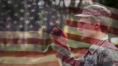 Parkta sallayan bir askeri nin dijital bileşimi ve arka planda el sallayan Amerikan bayrağı