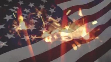 Kıvılcımların dijital bileşimi ve ön planda sallanan bir Amerikan bayrağı