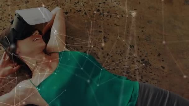 Цифровая Композиция Женщины Лежащей Носящей Гарнитуру Виртуальной Реальности Подключенными Линиями — стоковое видео