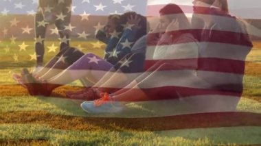 Güneşli bir günde açık havada oturup amerikan bayrağı sallayarak bir grup kadının dijital kompozit ön planda sallayarak