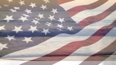 Ön planda bir Amerikan bayrağı ile gün batımında plaj dalgaları dijital kompozit