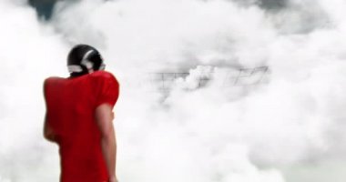 Bulutlu bir gökyüzü arka plan ile kutlayan bir Amerikan futbol atlet dijital kompozit. O heyecan 4k ile yere futbol atar