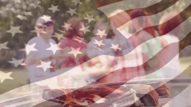前景に手を振るアメリカの旗を持つバーベキューを持つ友人のグループのデジタルコンポジット — ストック動画
