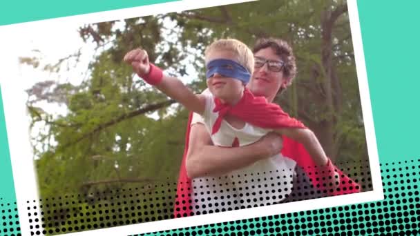 一个父亲抱着儿子假装在公园里飞翔的特写镜头 他们俩都穿着超级英雄的服装 — 图库视频影像