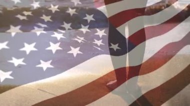 Gün batımında sahile bakan bir çift ayağın ön planda Amerikan bayrağı sallayarak dijital kompozit