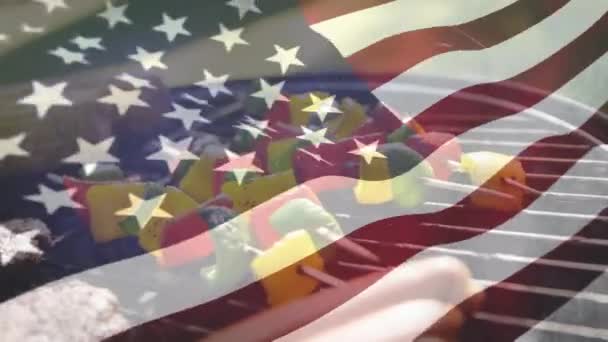前景を振るアメリカ国旗を持つグリルでバーベキューを焙煎するデジタルコンポジット — ストック動画