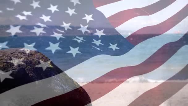 前景に手を振るアメリカ国旗を持つビーチのデジタルコンポジット — ストック動画