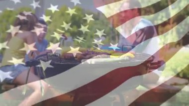 Ön planda sallanan bir Amerikan bayrağı ile piknik barbekü olan bir ailenin dijital kompozit